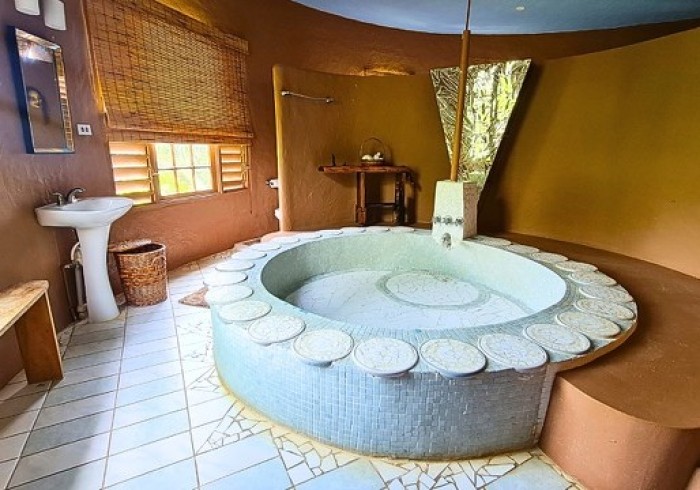 Spacious hut suite at Great Huts eco resort in Portland Jamaica with sitting area and art pieces