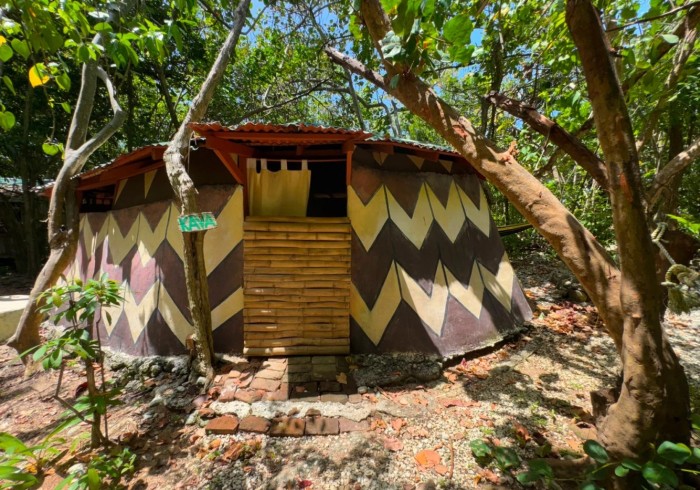 Spacious hut suite at Great Huts eco resort in Portland Jamaica with sitting area and art pieces