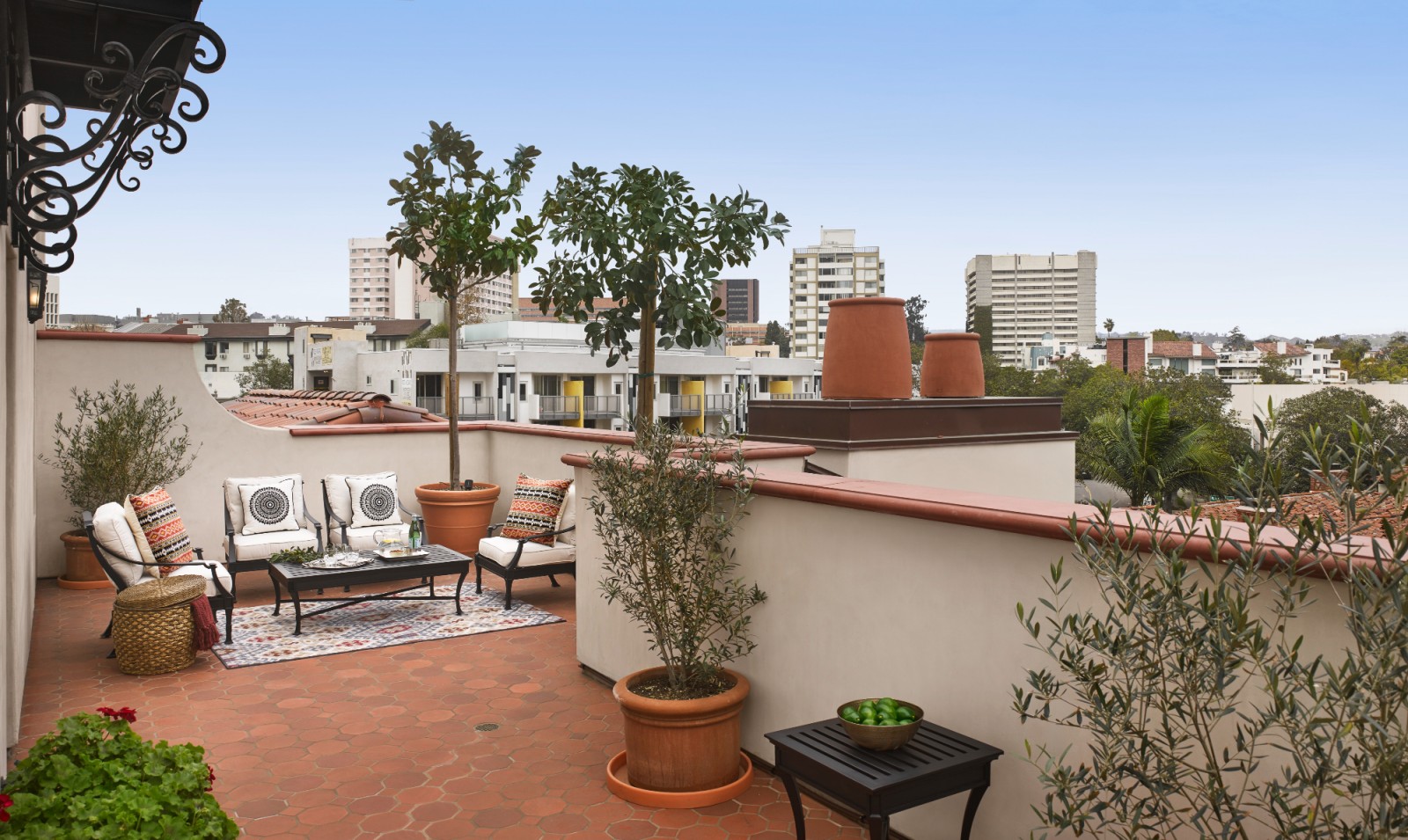 A rooftop patio with outdoor seating and city view